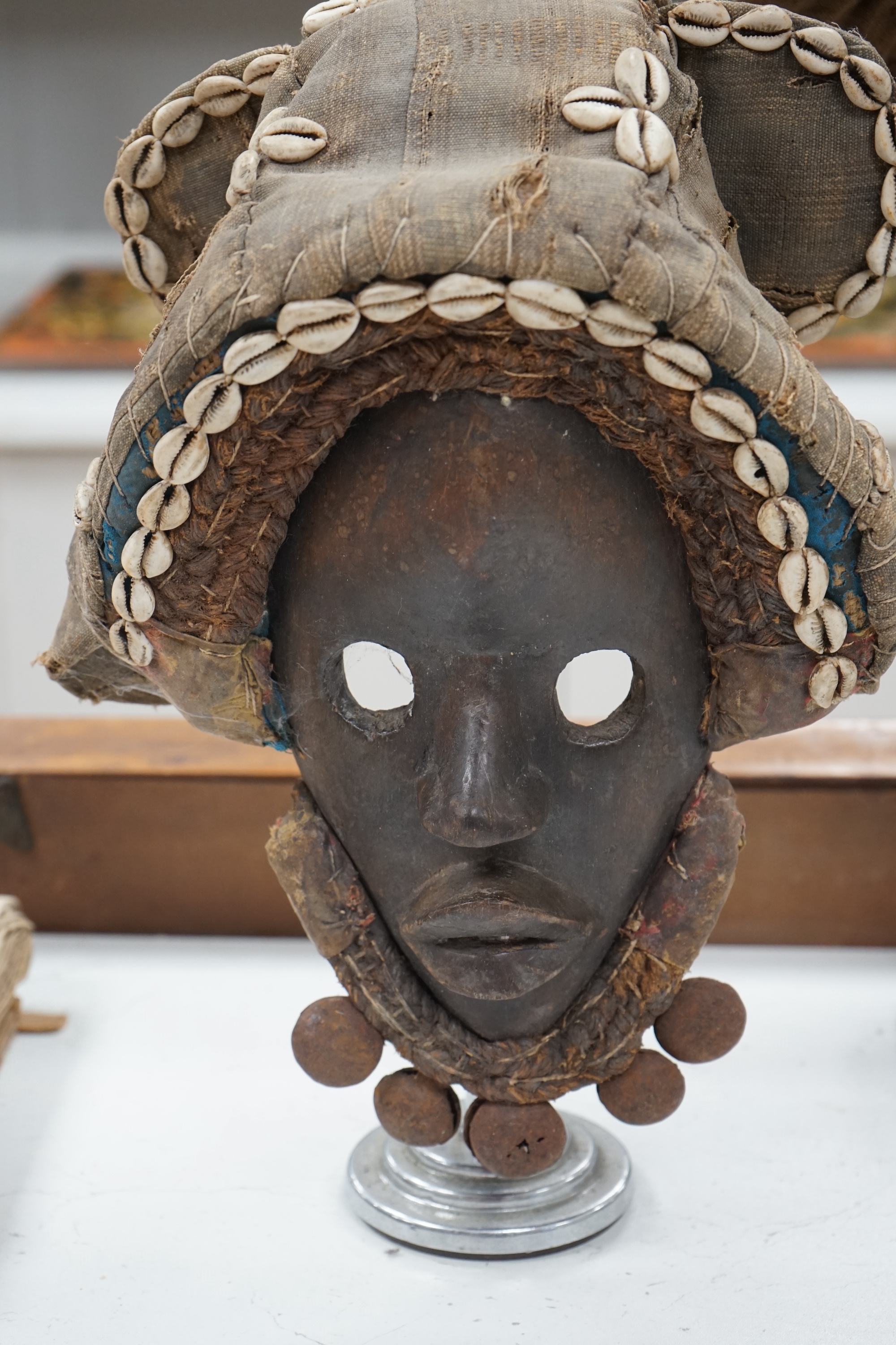 An African Ivory Coast/Liberian Dan mask together with another from the Democratic Republic Congo, both on stands, tallest 58cm including stand. Condition - some damage to the fabric of hats